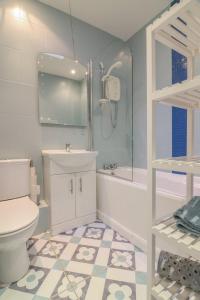 a bathroom with a toilet and a sink and a shower at GuestReady - Coastal Charm near Sandymount Beach in Dublin