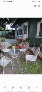 3 chaises et une table devant une maison dans l'établissement Camille's Cheapstay, à Alaminos