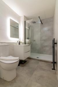 uma casa de banho branca com um WC e um chuveiro em GuestReady - City Centre Bliss in Temple Bar em Dublin
