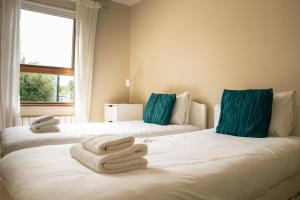 duas camas com toalhas num quarto em GuestReady - Epitome of Luxury near Shankill Beach em Dublin