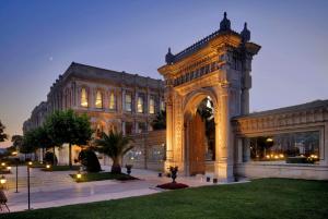 ein großes Gebäude mit einem Bogen davor in der Unterkunft Çırağan Palace Kempinski Istanbul in Istanbul