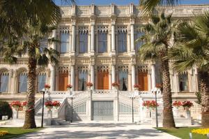 un bâtiment blanc avec des palmiers devant lui dans l'établissement Çırağan Palace Kempinski Istanbul, à Istanbul