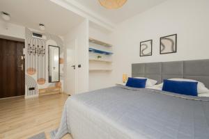 1 dormitorio con 1 cama grande con almohadas azules en Chmielna Apartments Warsaw Center by Renters, en Varsovia