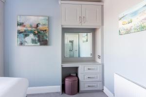 1 dormitorio con tocador blanco y espejo en GuestReady - Restful stay in Drimnagh, en Crumlin