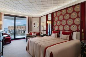 イスタンブールにあるシラガン パレス ケンピンスキー イスタンブールの大きなベッドとバルコニーが備わるホテルルームです。
