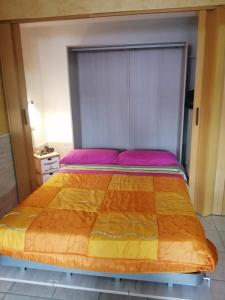 um quarto com uma cama grande com lençóis roxos e laranja em Starhouseavola em Avola