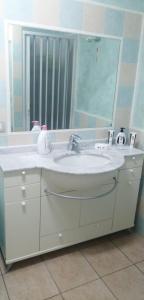 uma casa de banho com um lavatório e um espelho em Starhouseavola em Avola