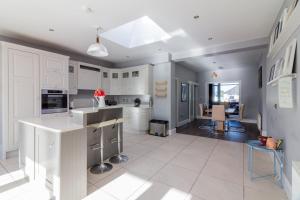 a large kitchen with white cabinets and a dining room at GuestReady - Restful stay in Drimnagh in Crumlin