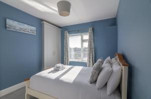 a bedroom with blue walls and a bed with pillows at GuestReady - Restful stay in Drimnagh in Crumlin