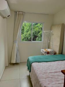 um quarto com uma cama e uma janela em Apartamento Lótus Ar Cond Pertinho FIG e Centro em Garanhuns