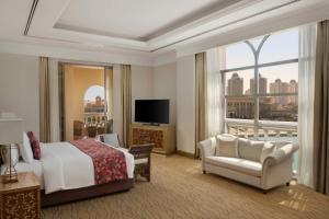 ein Hotelzimmer mit einem Bett und einem großen Fenster in der Unterkunft Marsa Malaz Kempinski, The Pearl in Doha