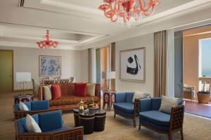 a living room with a couch and chairs and a chandelier at Marsa Malaz Kempinski, The Pearl in Doha