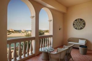 Habitación con balcón con mesa y sillas. en Marsa Malaz Kempinski, The Pearl, en Doha