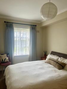 Un dormitorio con una gran cama blanca y una ventana en GuestReady - Lovely stay in Dublin, en Dublín