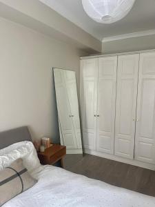 a bedroom with white cabinets and a bed and a mirror at GuestReady - Lovely stay in Dublin in Dublin