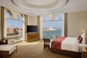 a hotel room with a bed and a large window at Marsa Malaz Kempinski, The Pearl in Doha