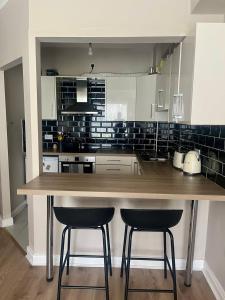 a kitchen with a large wooden counter with two bar stools at GuestReady - Lovely stay in Dublin in Dublin