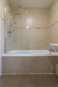 ein Badezimmer mit einer Dusche, einer Badewanne und einem Waschbecken in der Unterkunft GuestReady - Serene Haven near Castle Golf Club in Dublin