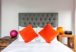 een slaapkamer met een bed met oranje kussens bij GuestReady - Tranquil Slumber in The Coast in Dublin