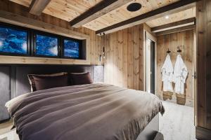 een bed in een kamer met houten wanden en ramen bij Chalet Strandafjellet in Stranda