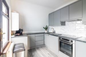 a white kitchen with white appliances and a window at GuestReady - Marvellous home in Seabury in Dublin