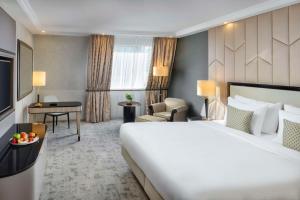 una camera d'albergo con un grande letto e una scrivania di Kempinski Hotel Corvinus Budapest a Budapest