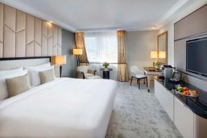 una camera d'albergo con un grande letto bianco e una scrivania di Kempinski Hotel Corvinus Budapest a Budapest