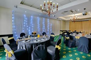 a conference room with tables and chairs and a chandelier at The Balmoral in Durban