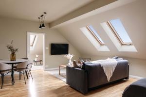 a living room with skylights and a couch and a table at TurnKey I Karlín Square Apartments in Prague