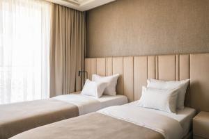 2 camas con almohadas blancas en una habitación de hotel en Hotel Kocka Vrnjačka Banja, en Vrnjačka Banja
