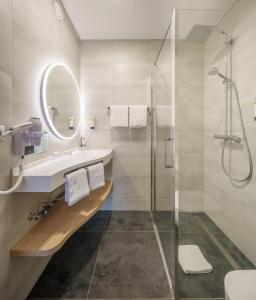 ein Bad mit einem Waschbecken und einer Dusche in der Unterkunft Hôtel Restaurant Ritter'hoft in Morsbronn-les-Bains
