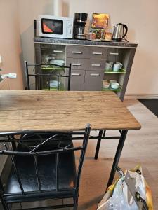eine Küche mit einem Holztisch und einer Mikrowelle in der Unterkunft Ap 2- 33 qm bei Oschersleben + Helmstedt in Ausleben