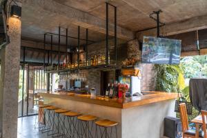 un bar con una fila de taburetes en un restaurante en The Sender Pool Suites, en Ubud