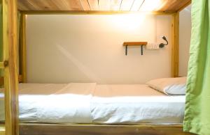 1 dormitorio con 2 camas en una habitación con pared en The Lost Hostels, Arugam Bay Beach - Sri Lanka, en Arugam Bay