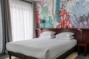 a bedroom with a large bed with a floral wall at Hôtel La Villefromoy in Saint Malo