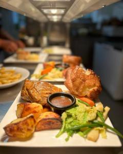 a plate of food with meat and vegetables on a table at The Squirrel in Godalming