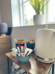 a table with a lamp and a bowl of toothbrushes at The Squirrel in Godalming