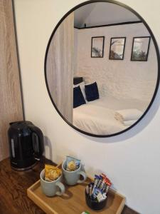 a mirror over a table with a bed in a room at The Squirrel in Godalming