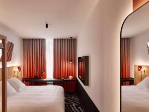 um quarto de hotel com duas camas e uma televisão em Mama Shelter Paris La Défense em Puteaux