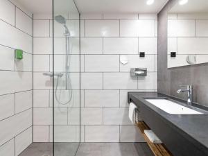 ein Badezimmer mit Dusche und Waschbecken in der Unterkunft ibis Styles Hamburg Barmbek in Hamburg