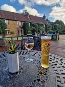 a glass of beer and a glass of wine on a table at The Squirrel Inn in Compton