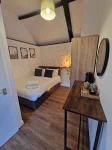 a bedroom with a bed and a table in it at The Squirrel in Godalming