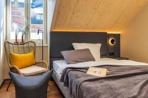 um quarto com uma cama grande e uma cadeira em Arthotel Bakker em Borkum