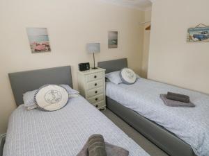 2 camas individuales en un dormitorio con tocador en Sandy Bay House, en Saundersfoot