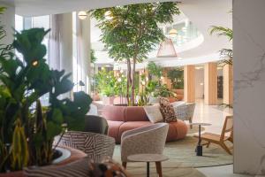 a lobby with a couch and chairs and plants at DoubleTree by Hilton Malta in St Paul's Bay