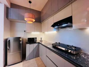a kitchen with white cabinets and a stainless steel refrigerator at Villa Aqua WIth Swimming Pool in Lucknow