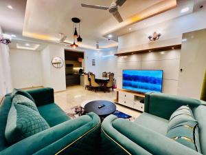 ein Wohnzimmer mit einem Sofa und einem Flachbild-TV in der Unterkunft Villa Aqua WIth Swimming Pool in Lucknow