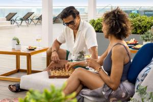 a man and a woman playing chess in a room at Hilton Cancun Mar Caribe All-Inclusive Resort in Cancún