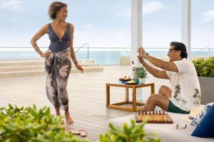 a woman playing chess with a man in a living room at Hilton Cancun Mar Caribe All-Inclusive Resort in Cancún