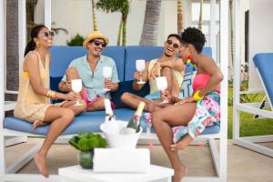 a group of people sitting on a blue couch at Hilton Cancun Mar Caribe All-Inclusive Resort in Cancún